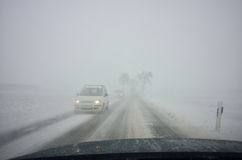 winter-driving-blizzard-cars-country-road-reduced-visibility-66165046