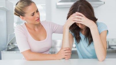 Woman in the kitchen comforting her upset friend